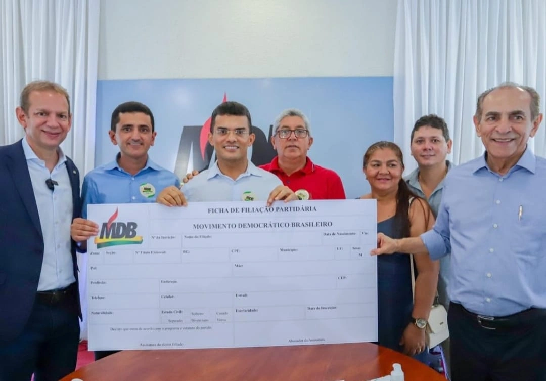 Antônio Luís Aninha no meio segurando a ficha de filiação partidária do MDB