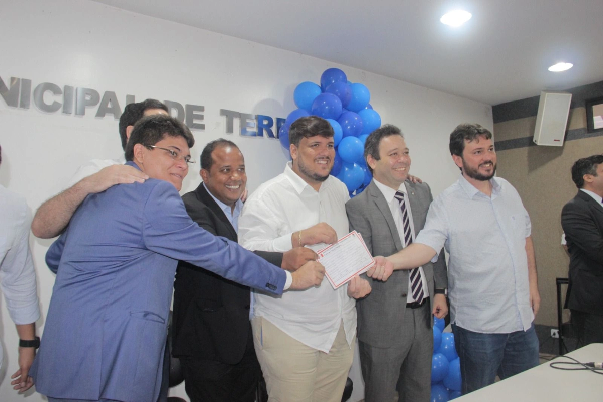 Jûnio Macêdo no meio com camisa branca segurando ficha de filiação