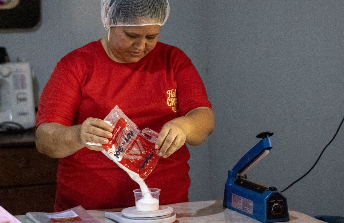 Dona Socorro pesa o sal e os chips para garantir a medida correta antes de ensacar