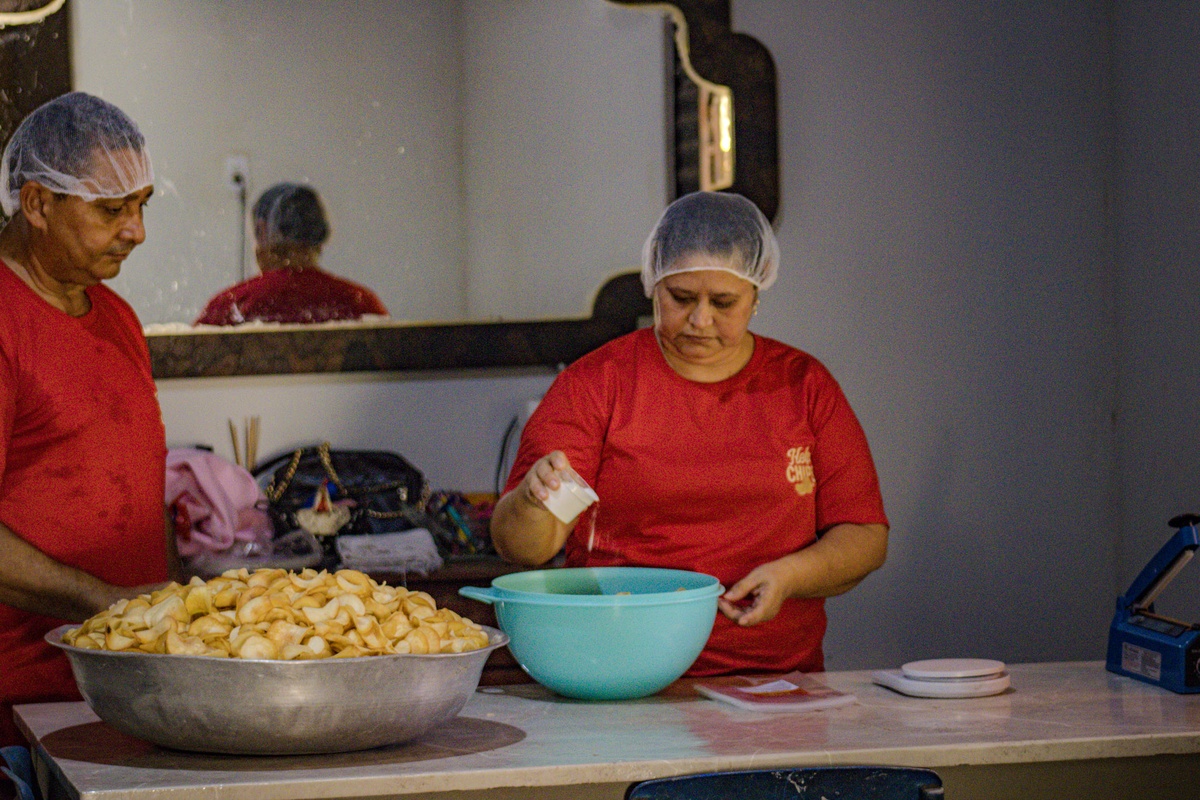 Fabiano e dona Socorro trabalham juntos para salgar e ensacar os chips